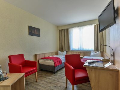 Rügenhotel Zweibettzimmer Landseite Betten Sessel Fernseher